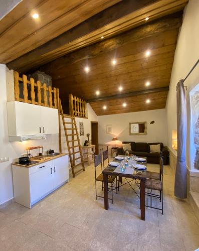 a kitchen and a living room with a table and chairs at Refugio das Terras Altas in Ribeira de Pena