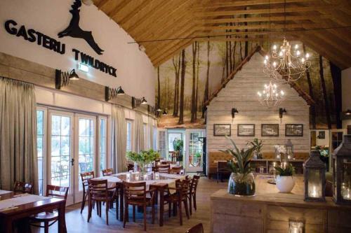 a restaurant with wooden tables and chairs and a chandelier at Vakantiehuis Diever in Diever