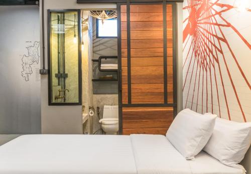 a bedroom with a white bed and a toilet at Sea Crest by Jomtien in Jomtien Beach