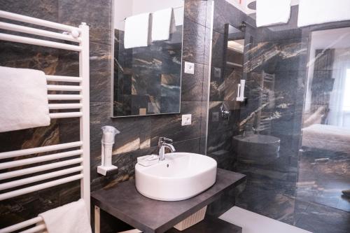 a bathroom with a sink and a mirror at Hotel Elys in Pieve Emanuele