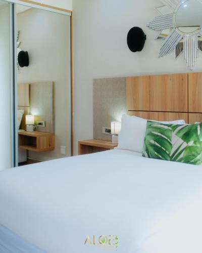 a bedroom with a bed and a mirror at Aloe Lifestyle Hotel in Eshowe