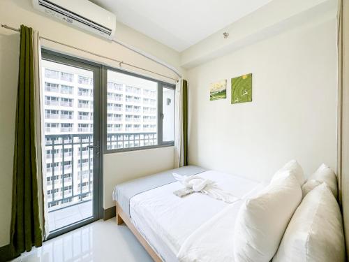 a bedroom with a bed and a large window at GemstoneBR in SMDC Fame Residences in Manila