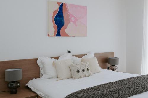 a bedroom with a bed with white sheets and pillows at Villa Oleander by Domus Mirus - Rooftop Cinema & Pool & 6min Walk to Beach in Splitska