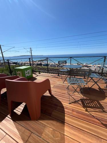 une terrasse en bois avec un banc sur la plage dans l'établissement La Pitchounette bord de mer, à Cannes