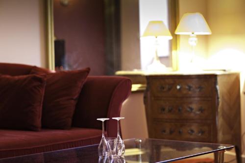 a living room with a red couch and a dresser at Demeures & Châteaux La Belle Meuniere in Royat
