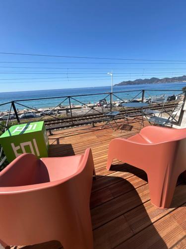une terrasse avec bancs et vue sur la plage dans l'établissement La Pitchounette bord de mer, à Cannes