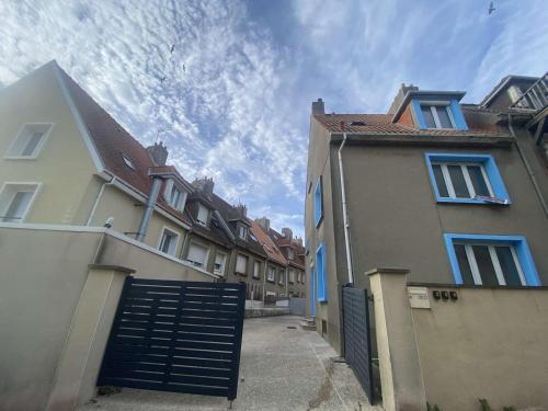 a group of buildings with a gate in a courtyard at Chambre privée à 50 m de la plage salle de bain et cuisine commune in Le Portel