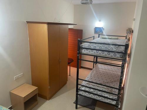 a room with two bunk beds and a wooden cabinet at Neha's Homestay in Mysore