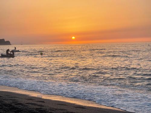 a group of people in the ocean at sunset at Al Hoceima Hay Bades Villa in Al Hoceïma