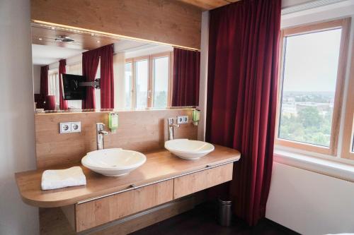ハンブルクにあるBettenburg Hotelの洗面台が2つと大きな鏡があるバスルーム