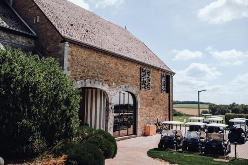 a brick building with tables and chairs in front of it at Hôtel & Restaurant Five Nations in Durbuy