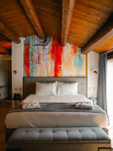 a bedroom with a large bed with a painting on the wall at Dimora Bonafede Ibla Design Rooms in Ragusa