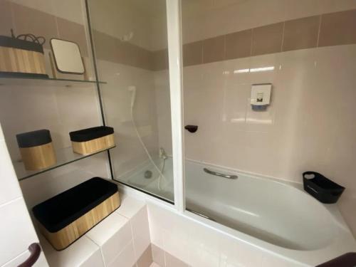 a bathroom with a shower and a toilet and a tub at Appartement au Parc de la Grange in Jard-sur-Mer