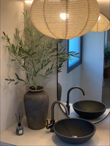 a bathroom with two sinks and a potted plant at Komi Beach Apartment in Kómi