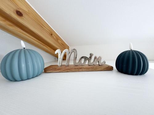 two blue candles with the word mum on a wooden shelf at Haus Seeblick mit 9 Wohnungen in Alt Reddevitz