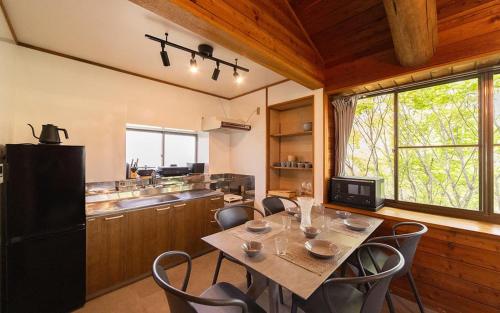 a dining room with a table and chairs in a kitchen at rinne 2nd living Kitakaruizawa Garden in Tsumagoi