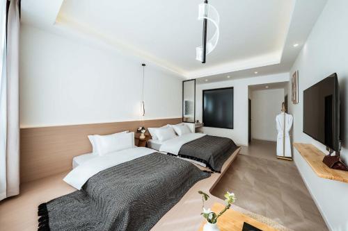 a bedroom with two beds and a flat screen tv at 山也云也大理古城南门店 in Dali Ancient Town