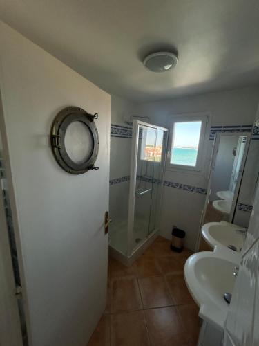 a bathroom with two sinks and a shower and a mirror at Superbe appartement 2 chambres face à la mer au Grau du Roi l'Impérial in Le Grau-du-Roi