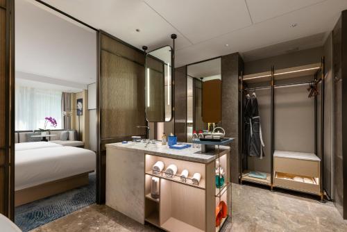 上海上海虹桥荷逸唐酒店北新泾地铁站Shanghai Hongqiao Heyitang Hotel Beixinjing Subway Station Branch的一间带床的卧室和一间带水槽的浴室