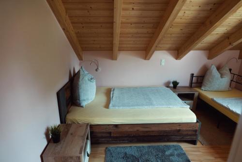 a bedroom with two beds and a wooden ceiling at Haus am See Ferienhaus 4 in Wackersdorf