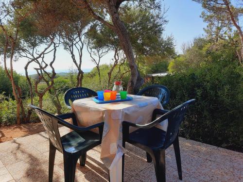 a table with chairs and a plate of food on it at Villette Vista Mare in Rena Majore