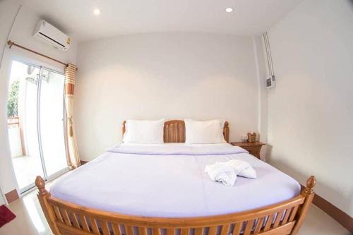 ein Schlafzimmer mit einem großen Bett mit zwei Handtüchern darauf in der Unterkunft Kannika Place in Nakhon Phanom