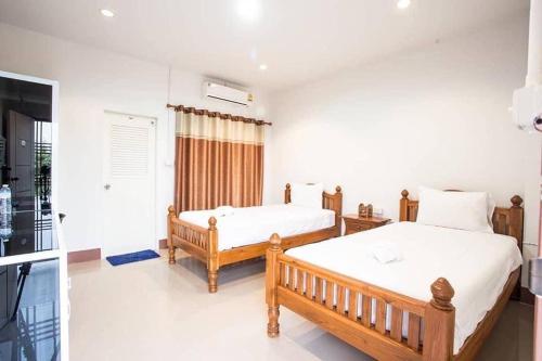 ein Schlafzimmer mit zwei Betten und einem Fenster in der Unterkunft Kannika Place in Nakhon Phanom