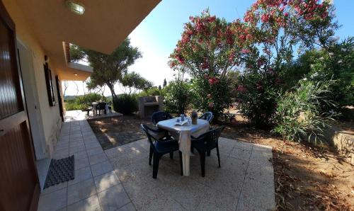 a table and chairs on a patio with flowers at Villette Vista Mare in Rena Majore