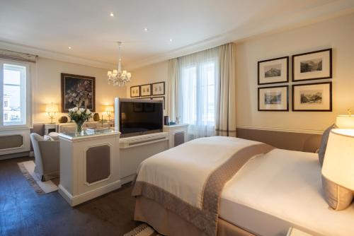 a bedroom with a bed and a flat screen tv at Hotel Sacher Salzburg in Salzburg