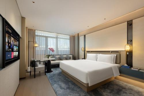 a hotel room with a large bed and a television at Shanghai Hongqiao Heyitang Hotel Beixinjing Subway Station Branch in Shanghai
