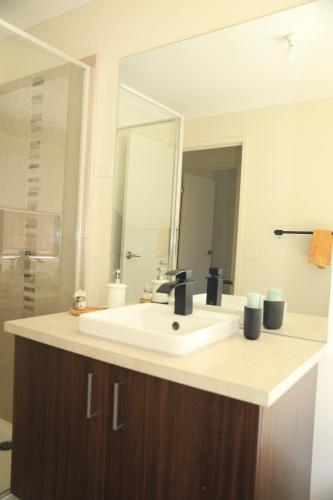 a bathroom with a white sink and a mirror at Family Home in Truganina in Truganina
