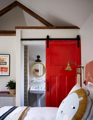 a red door in a bedroom with a sink at Artist Residence Cornwall in Penzance