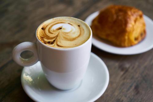a cup of coffee and a pastry on a table at Yposkafon Concept Two-Bedroom Villa with Private Jacuzzi and Hamam in Megalokhori