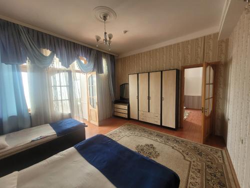 a bedroom with two beds and a large window at STOP Hotel in Sheki