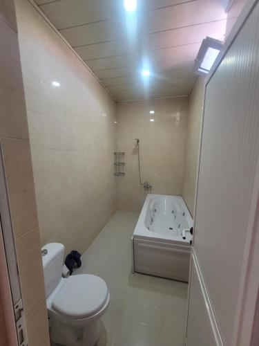 a bathroom with a toilet and a bath tub at STOP Hotel in Sheki
