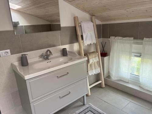 a bathroom with a white sink and a window at Lucciano Suite in Quarrata