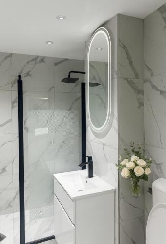 a bathroom with a white sink and a mirror at House Elisa in Sighetu Marmaţiei