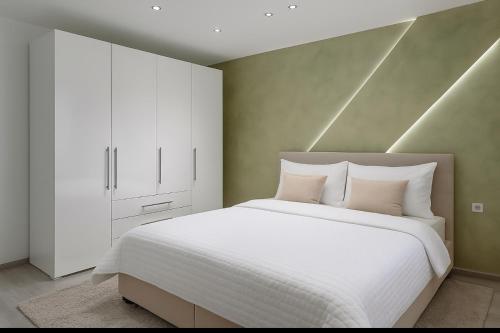 a bedroom with a large white bed and a white cabinet at House Elisa in Sighetu Marmaţiei