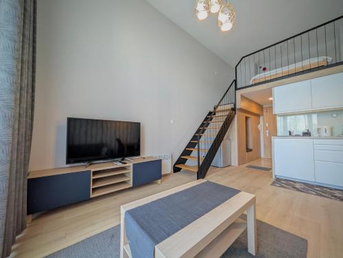a living room with a television and a staircase at Sky Loft Wrocław Apartment by BookingHost in Wrocław
