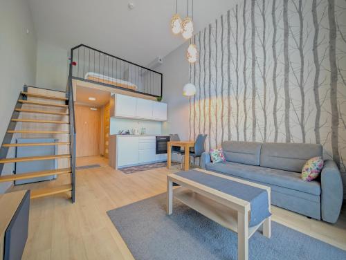 a living room with a couch and a loft bed at Sky Loft Wrocław Apartment by BookingHost in Wrocław