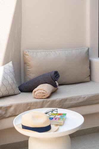 a couch with a hat and a table at The Cosmopolitan - Karterados Urban Suites in Karterados