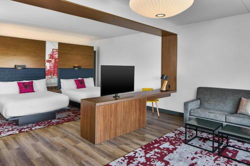 a living room with a tv and a couch at Aloft Raleigh in Raleigh