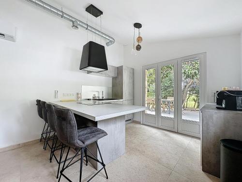 - une cuisine avec un comptoir et quelques chaises dans l'établissement Villa 2 chambres avec jacuzzi, à Bonifacio