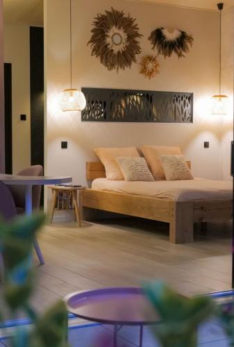 a bedroom with a bed and two tables and chairs at L'écolodgia suite & spa in Saint-Étienne-lès-Remiremont