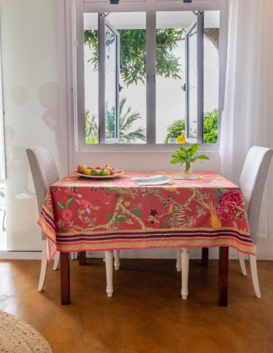 a table with a plate of fruit on it in front of a window at Lakaz Kreol Soupir Tourist Résidence in Rodrigues Island