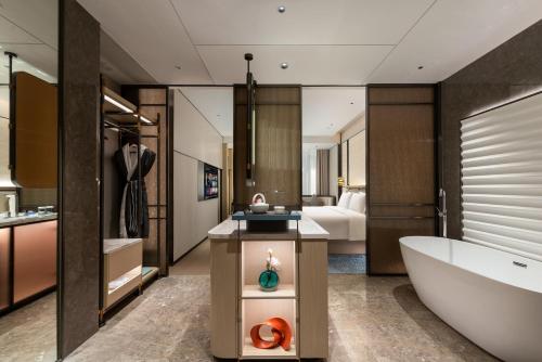 a bathroom with a bath tub and a bedroom at Shanghai Hongqiao Heyitang Hotel Beixinjing Subway Station Branch in Shanghai
