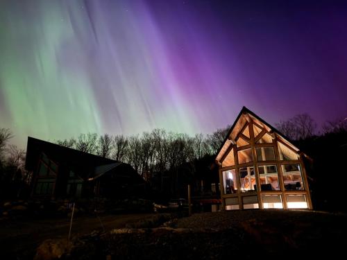 a house with a rainbow in the sky at Chalet en montagne - Spa et Ski - Le Goathouse in Saint-Philémon
