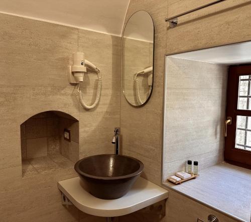 a bathroom with a bowl sink and a mirror at Kalemi Twin Boutique Hotel in Gjirokastër