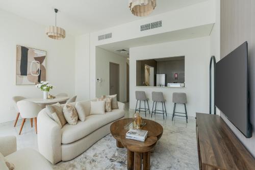 a living room with a white couch and a table at Nasma - RAK Bliss 2BR Villa, Maid Room & Backyard in Ras al Khaimah