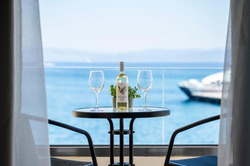 a table with two glasses and a bottle of wine at Avra Suites in Kos Town